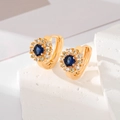 Macro shot of sunflower earrings with deep blue zircon and white diamonds on gold base - Blue