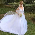 Elegant white lace wedding dress with long sleeves and cathedral train on outdoor lawn - US Size 2 (S) / White