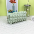 Détail macro d'une trousse vert menthe à texture gaufrée avec fermeture éclair - Vert