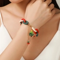 Christmas charm bracelet with red and green links and a golden tree pendant on wrist - Christmas Tree