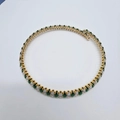 Detail of vintage gold necklace featuring emerald green and clear zircon pavé settings - White + Green