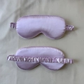 Lavender satin silk sleep masks with elastic headbands on a soft fabric background - Light Purple