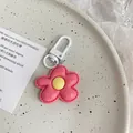Close-up of pink flower keychain with yellow center and white carabiner hook on tray - Rose Red