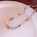 Colorful baroque beaded necklace with red and blue accents on a ceramic plate - Blue Faux Stone Crystal Necklace (#17)