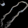 Macro detail of luxury silver fringe necklace with shimmering tiered crystals on black background - Silver