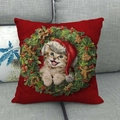 Housse de coussin avec chat rouge et couronne de Noël sur un canapé gris - Fond Rouge Chat Couronne