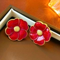 Detailed view of red enamel flower earrings with gold trim on a brown jewelry tray - Silver Earring Post Style / Red