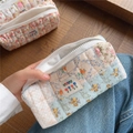 Detailed close-up of quilted floral cosmetic bag with patchwork design and zipper - Blue Floral Padded