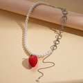 Detailopname van asymmetrische parelketting met een realistische rode aardbeihanger - Parel en Metalen Ring Splicing Stijl