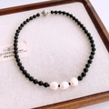 Dettaglio della collana con perle di vetro nero e tre perle d'acqua dolce bianche naturali - Collana-Nero-Bianco