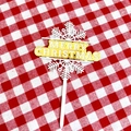 Macro detail of Merry Christmas cake topper with golden text on festive plaid fabric background - Snowflake 2 White Gold Merry Christmas