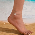 Close-up of silver double-layered anklet with star pendant worn on a sunny beach - Steel Star Anklet