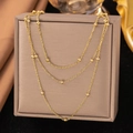 Elegant multi-layer gold bead necklace presented on a luxury jewelry display box - Three-layer Beaded Station Chain (QZXLH178) / Gold