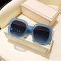 Primer plano de montura cuadrada azul claro con purpurina y lentes degradadas oscuras - Marco Azul Lentes Azul Grisáceo