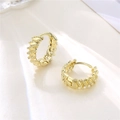 Elegante 18K Gold Creolen mit gedrehtem Muster auf beige Seidenhintergrund - Gold