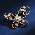 Detailed view of a gold butterfly brooch with shimmering rhinestones on blue background - Iridescent Butterfly
