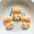 Close-up of orange mushroom resin charms for DIY crafts inside a white ceramic bowl - Mushroom
