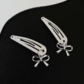 Paire de pinces à cheveux en métal argenté avec pendentifs nœuds sur fond noir - 7 Nœud (Paire)