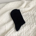 Mid-calf black cotton socks with vertical ribbed texture on a white knitted blanket - Black