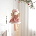 Detail of pink plush Christmas angel pendant with gold wings hanging on pine branch - Pink