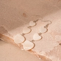 Detail of elegant triple heart drop earrings with shimmering mother of pearl texture - White Mother Of Pearl Look Heart Drop Earrings