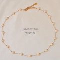 Detail view of gold pearl necklace on silk background with length and weight specs - Pearl Starry Sky