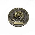 Macro shot of a bronze dog tag featuring a detailed Chow Chow relief and engraving space - Chow Chow