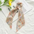 Floral chiffon hair scrunchie with long ribbon streamers for elegant ponytail styling - Orange