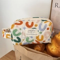 Dettaglio della borsa da trucco trapuntata con motivi a U colorati ed etichetta tessuta - UU Colorato [Borsa da polso]
