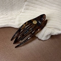Tortoiseshell resin hair clip with brand logo on beige knit and wood background - Coffee Tortoiseshell Round Label Swallowtail Clip