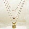 Detail van de drielaagse gouden ketting met hart-, ster- en maan-emaille hangers - Wit