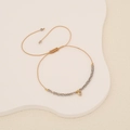 Handmade woven crystal heart bracelet with khaki cord and grey beads on white display - Light Gray