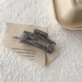 Detail der grau-blauen Haarklammer mit Marmormuster aus Acetat auf beigem Stoff - Grau