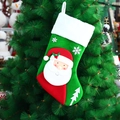 Knitted Christmas stocking with 3D Santa and snowflake patterns hanging on a tree - Santa Claus