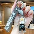Portachiavi astronauta con sabbia mobile dorata, finitura in oro nero e cinturino in silicone - Astronauta Oro Nero - Viso Giallo Seduto