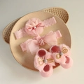 Detailed view of pink baby lace headband and bow socks set on a textured ceramic tray - Pink Pompom Mesh Headband + Openwork Socks