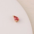 Macro detail of a pink teardrop zircon charm with gold-plated setting on a beige tray - Pink (10#)