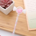 Creative transparent liquid pen with pink sequins and peach candy topper on wood - Candy White