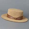 Detalle de sombrero canotier de rafia con textura de paja y lazo marrón - Marrón