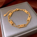 Detail of vintage gold flower bracelet with hollow floral charms on silk background - Gold