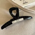 Large black resin shark hair clip featuring a silver rectangle logo plate for women - Silver Cross MIU Style