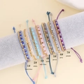Detalle de siete coloridas pulseras bohemias tejidas en un soporte de terciopelo gris - Azul Oscuro (1#)
