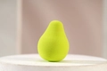 Pear-shaped green makeup sponge blender with soft porous texture on a white display stand - Light Green Pear