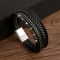 Close-up of woven black leather bracelet with stainless steel magnetic clasp on wood - Silver & Black