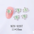 Détail de breloque ongle coeur argenté avec pierre œil de chat verte et strass fins - Cœur vert clair avec cadre argenté (9207)