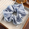 Close-up of blue plaid silk scrunchie with lace edge in a beige jewelry gift box - Blue Satin With Ribbon Bow