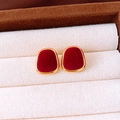Macro detail of red flocked earrings with gold metal frame on a velvet jewelry display - Square / Red
