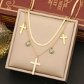 Double-layered gold necklace with crystal cross and turquoise beads in a jewelry box - Necklace