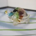 Close-up of resin turtle figurine with colorful crystal stones and gold foil flakes - Colorful Cat Eye