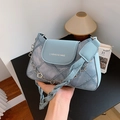 Borsa a tracolla in denim azzurro con catena e manico superiore tenuta in mano - Blu